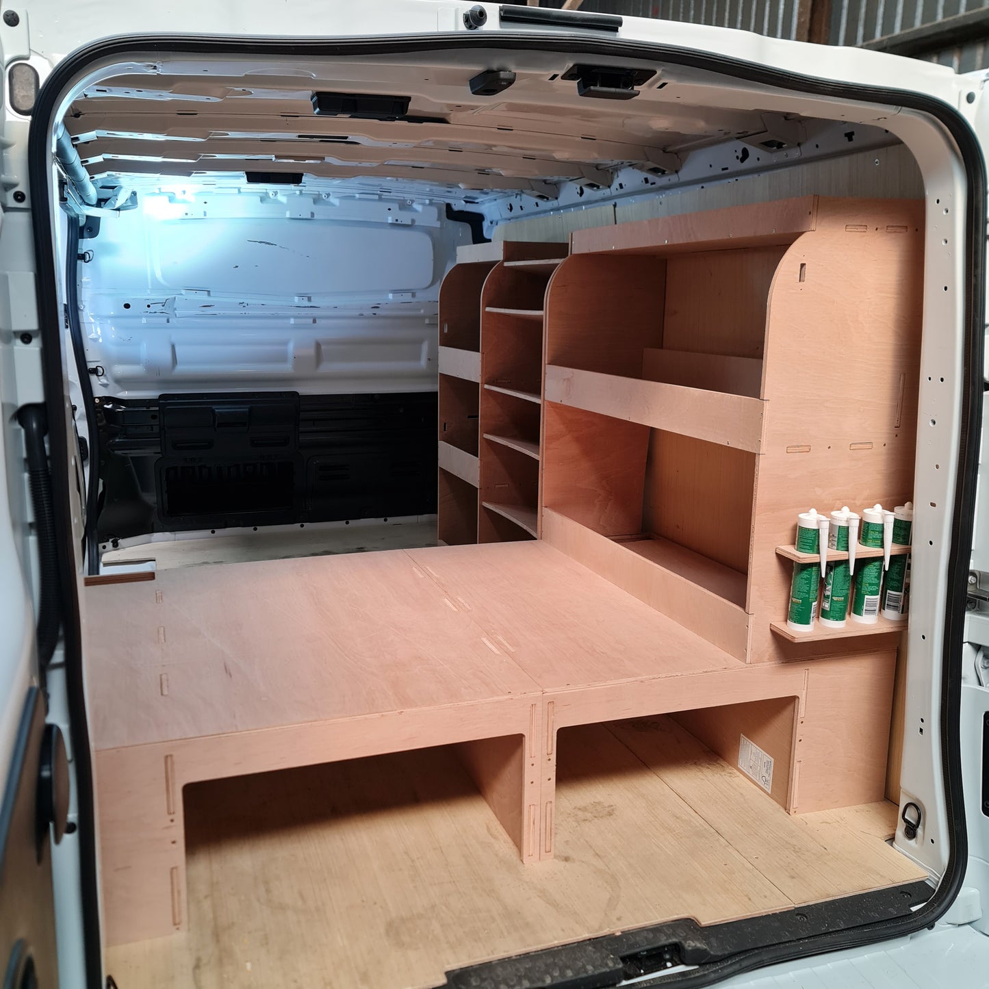 A custom-fit plywood false floor and plywood racks installed in the interior of a Citroën Dispatch van, designed for tool and equipment storage.