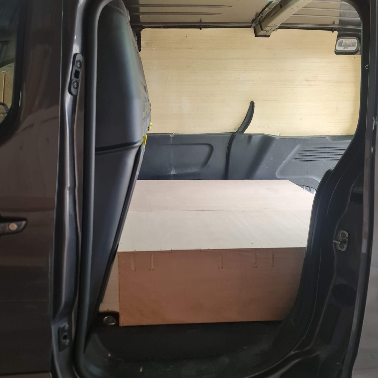 Open car door revealing a wooden floor inside the vehicle
