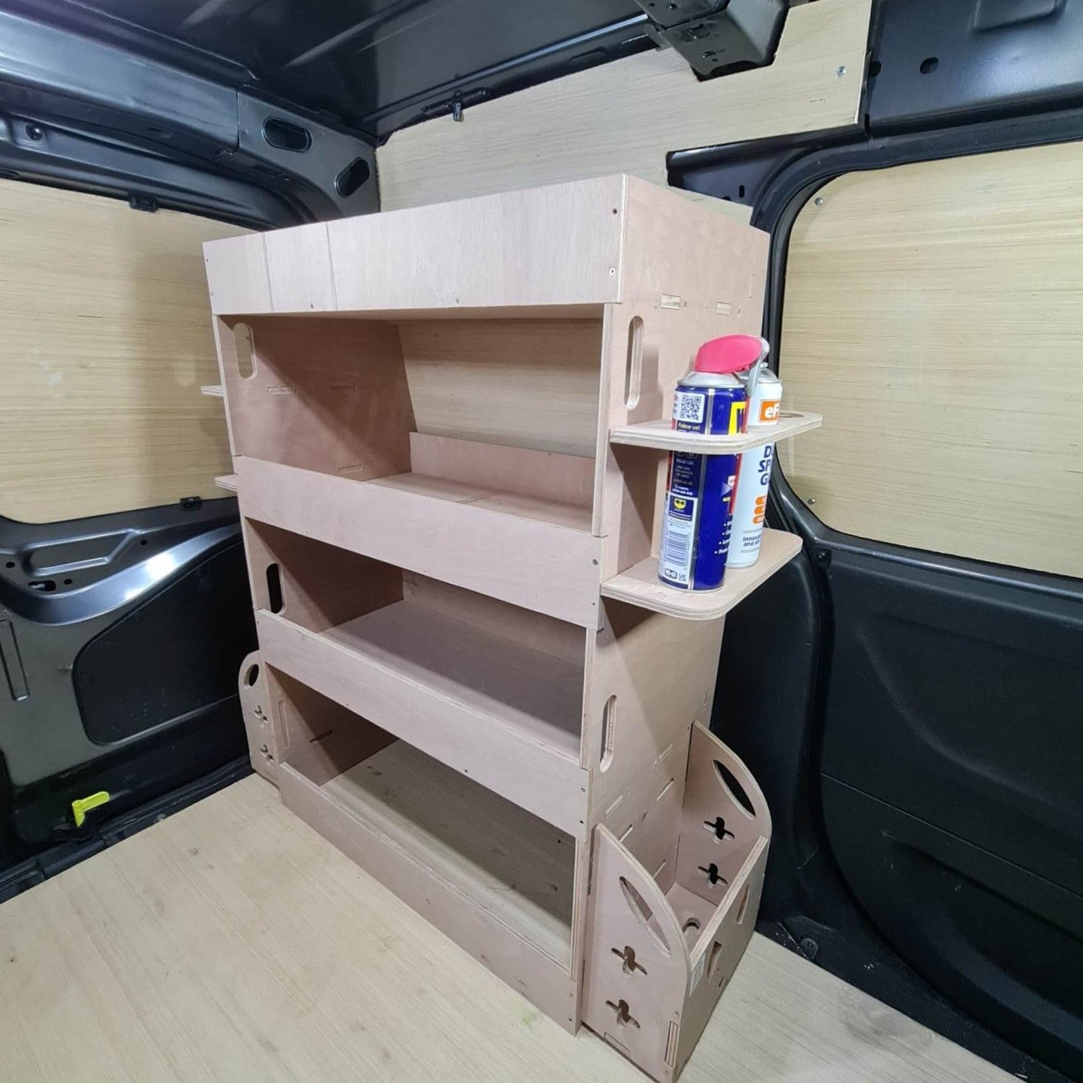 Wooden shelf unit inside a vehicle with various items on top