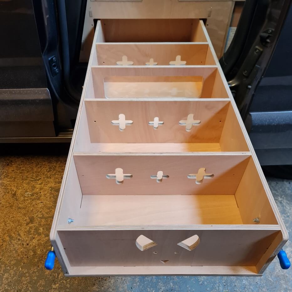 Wooden drawer unit with multiple compartments on wheels in a garage setting