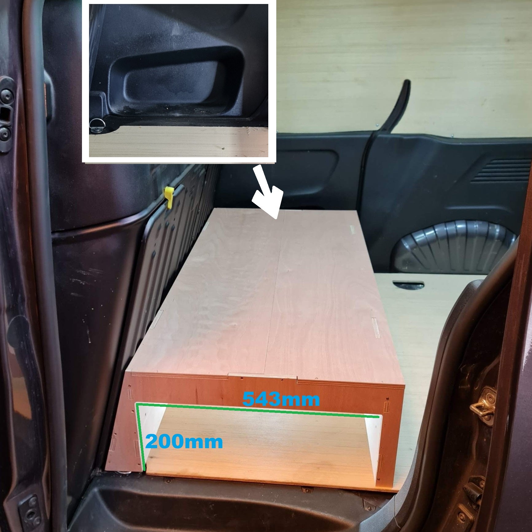 Wooden board with measurements inside a vehicle, showing a close-up of a car door handle.