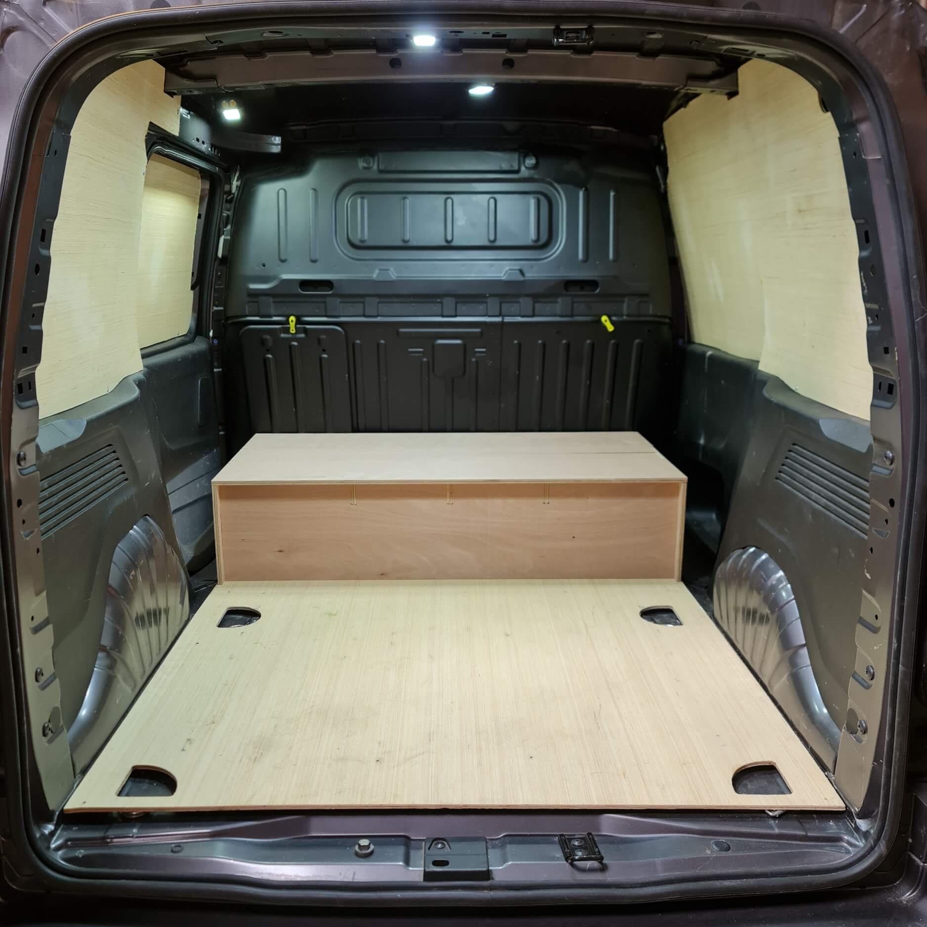 Van interior with a wooden platform and storage area