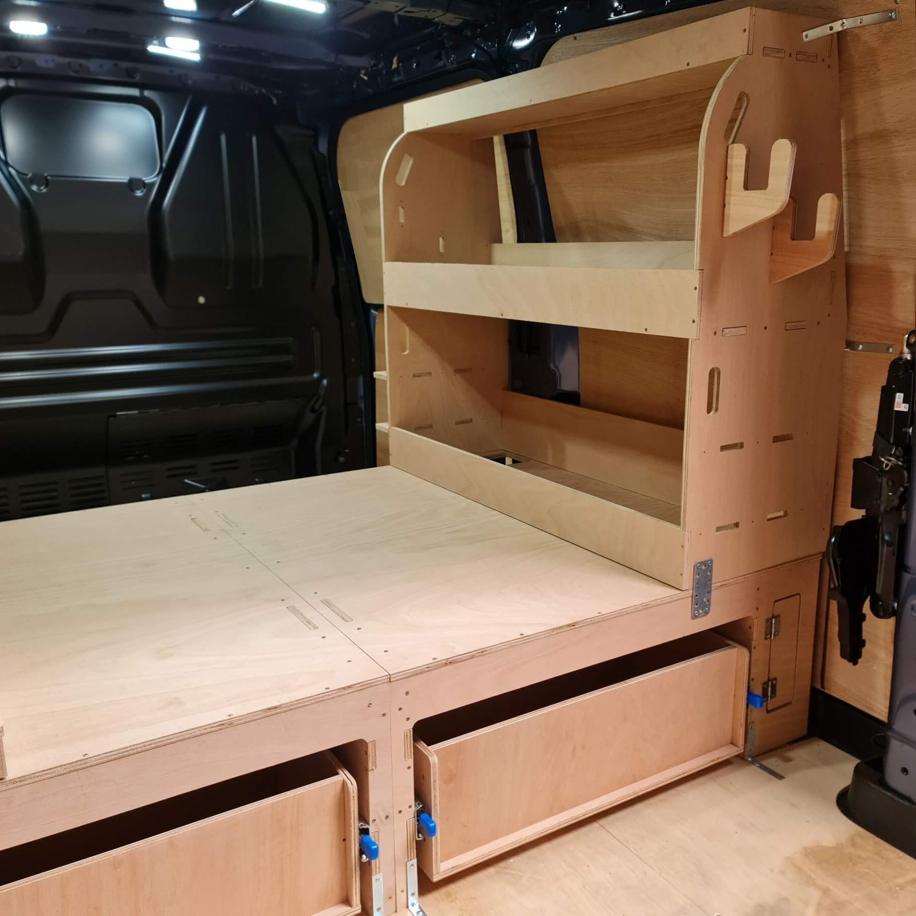 Wooden bed and storage system inside a van