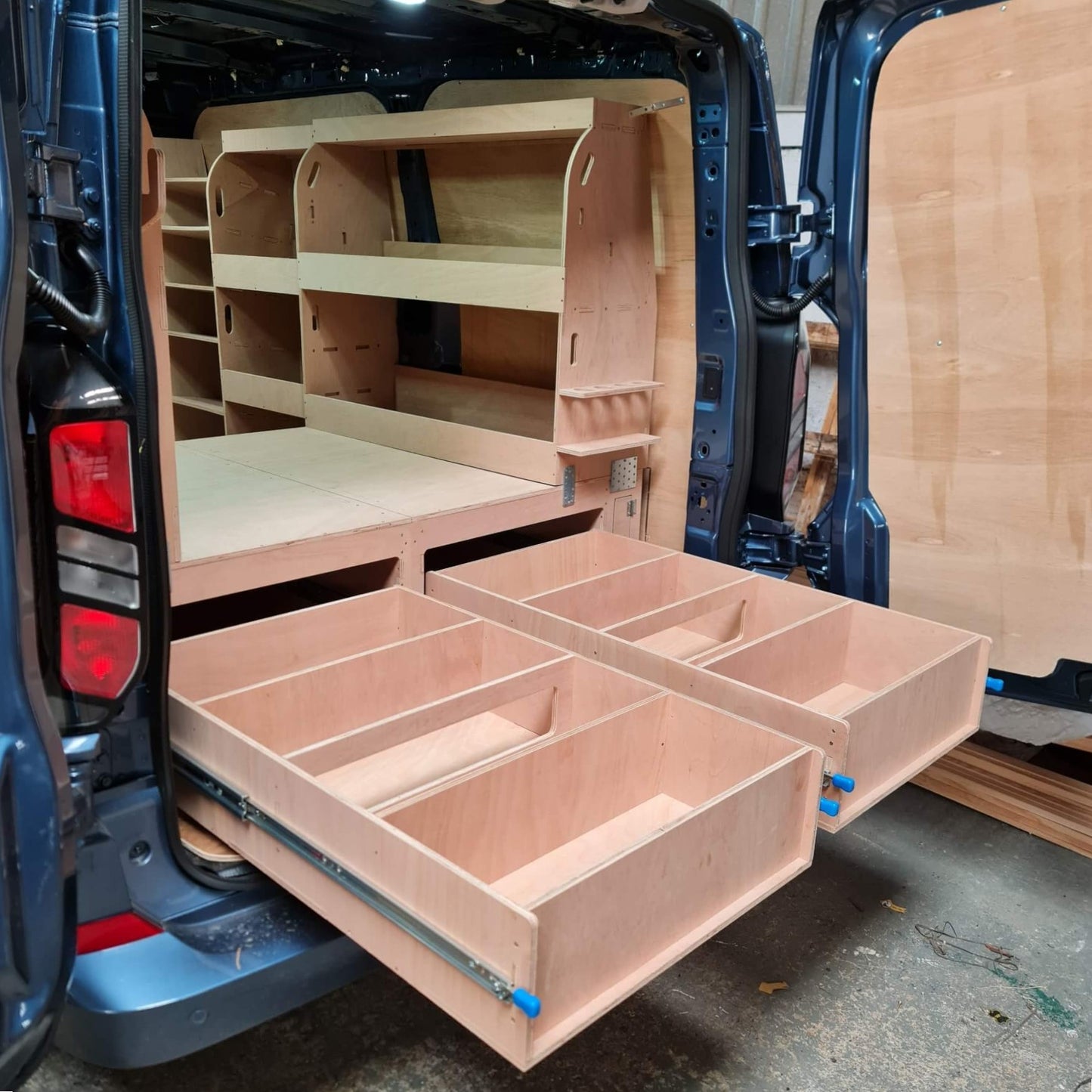 Wooden storage compartments installed in the back of a van.