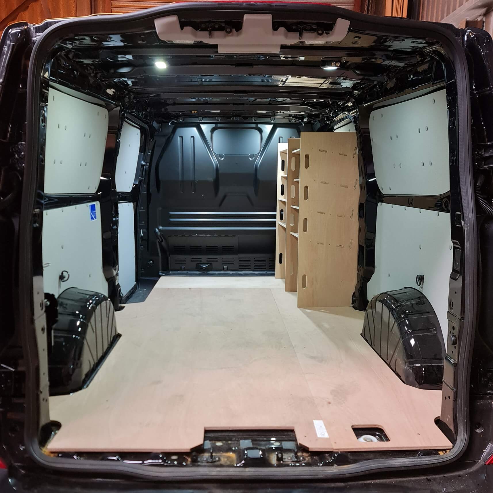 Ford Custom van racking system with plywood shelves for tool storage, perfect for electricians and plumbers