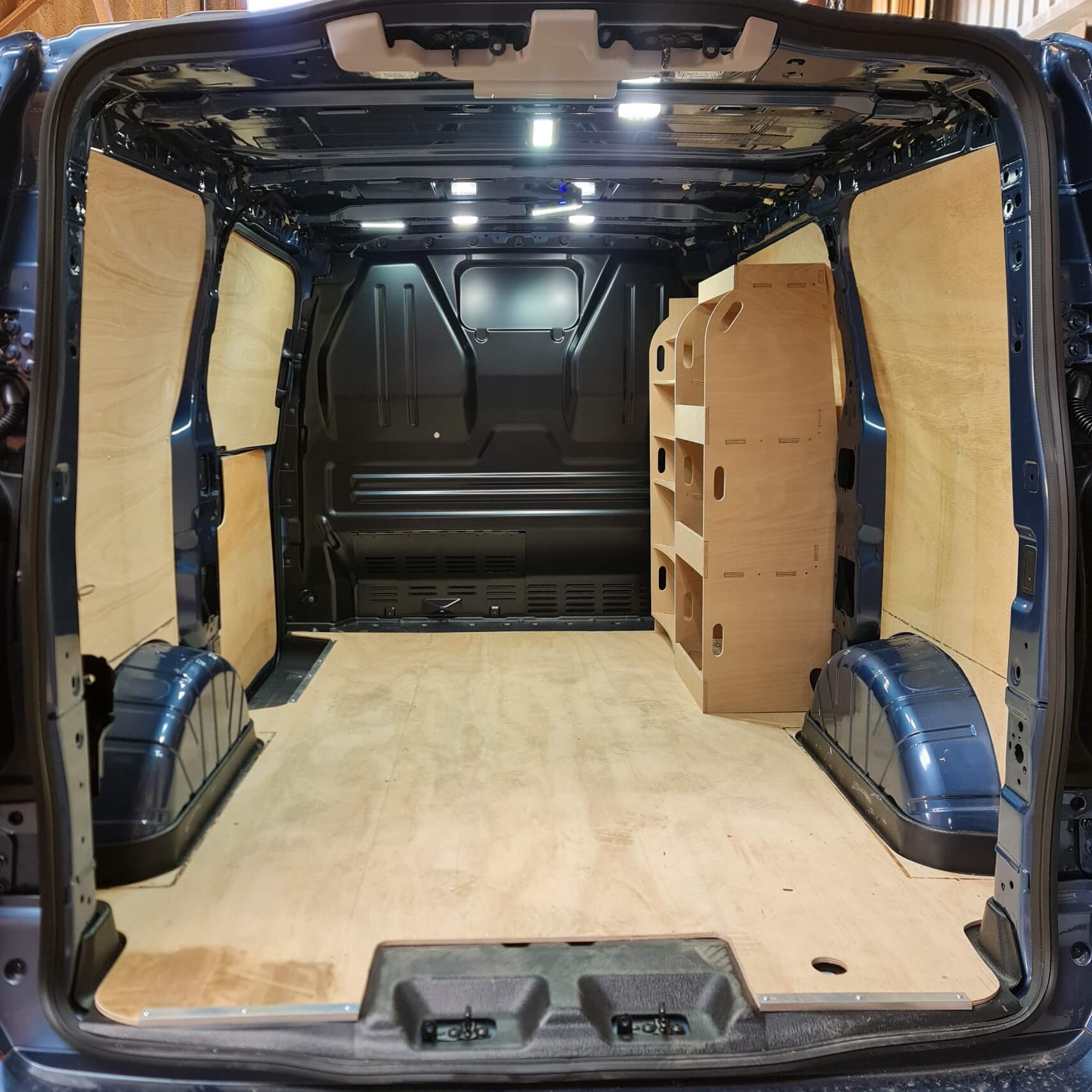 Ford Custom van racking system with plywood shelves for tool storage, perfect for electricians and plumbers