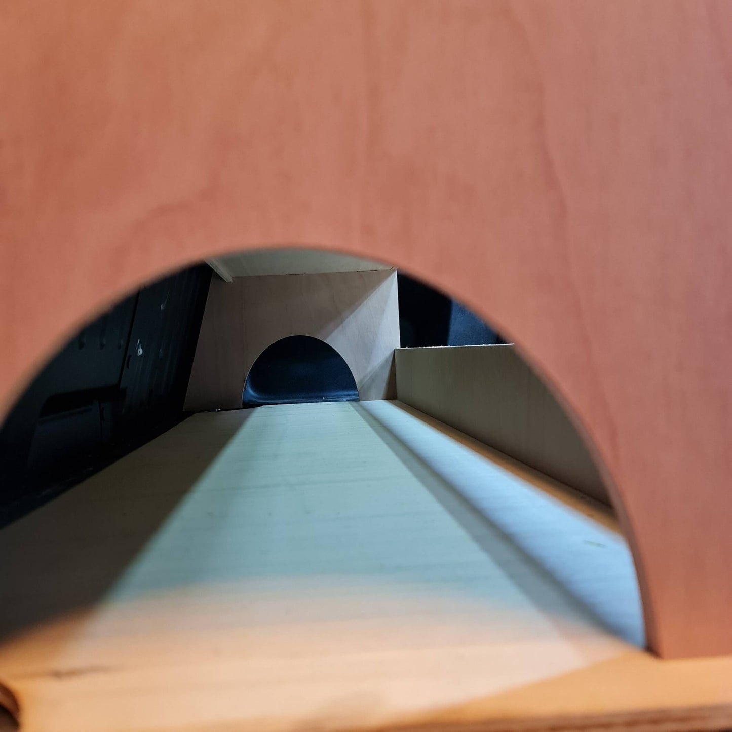 Wooden racking with a circular cutout revealing a dark interior