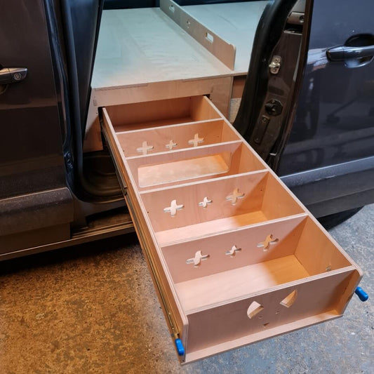 Wooden drawer system attached to a vehicle with open doors