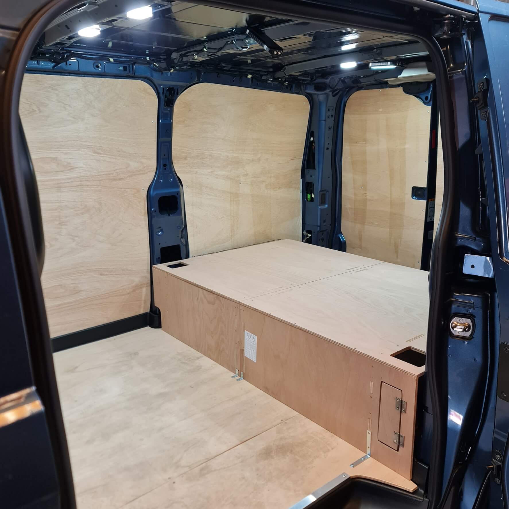 Van interior with wooden paneling and storage compartment
