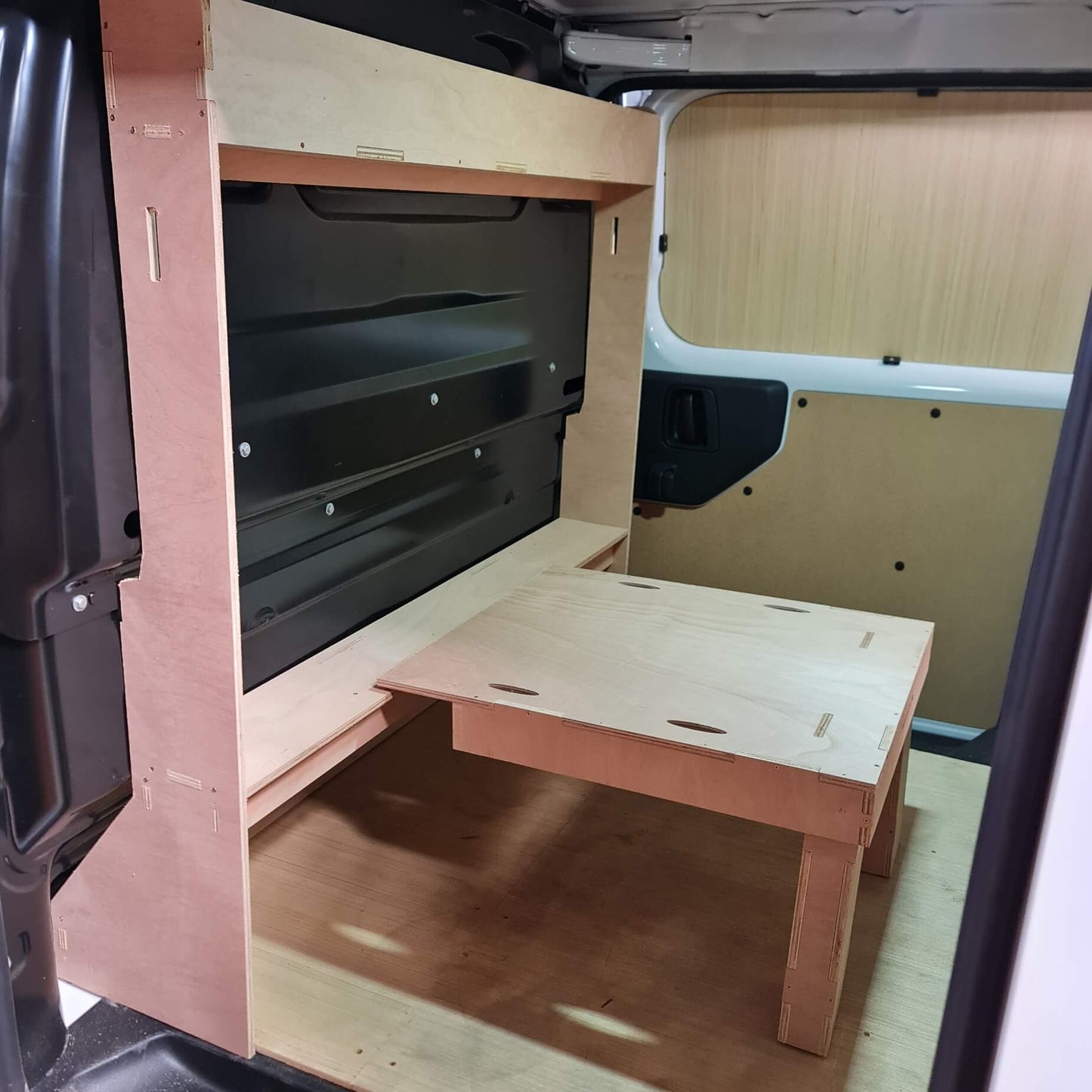 Wooden desk inside a van with open doors