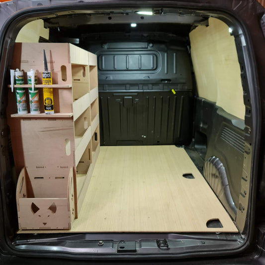 Van interior with wooden shelves and storage compartments.