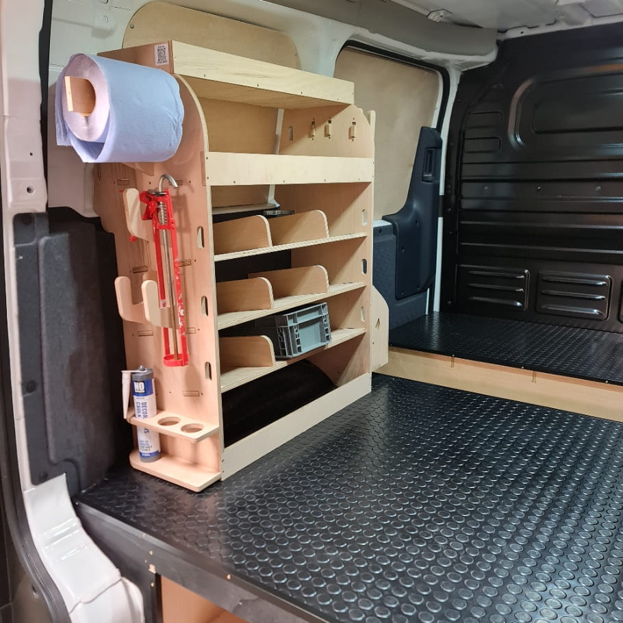 Wooden shelf system inside a kia pv5 van with various tools and supplies.
