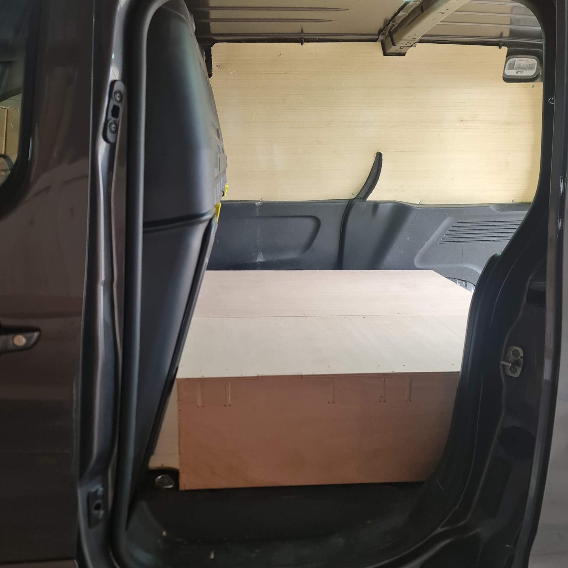 Open car door revealing a wooden floor inside the vehicle