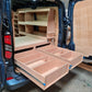 Wooden storage compartments installed in the back of a van.