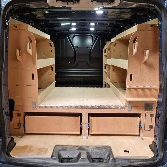 Van interior with wooden shelves and a bed setup