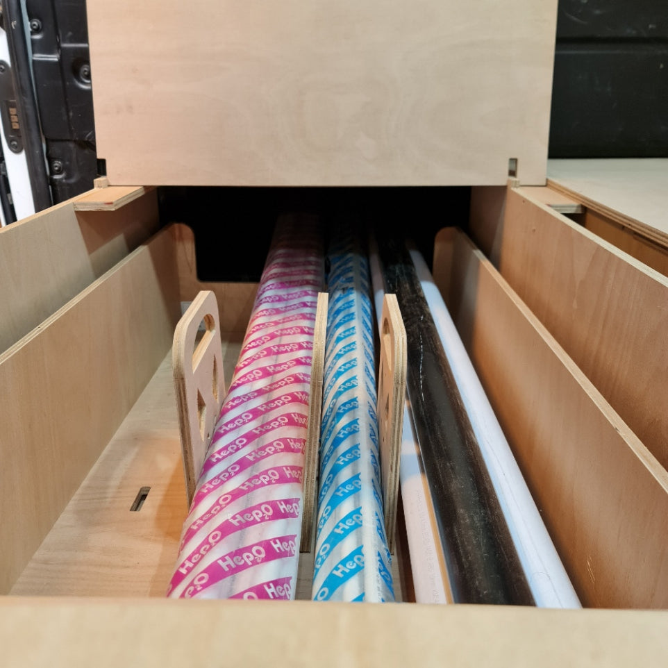 Ford Custom False storage under with shelves holding various materials including paper and plastic sheets.