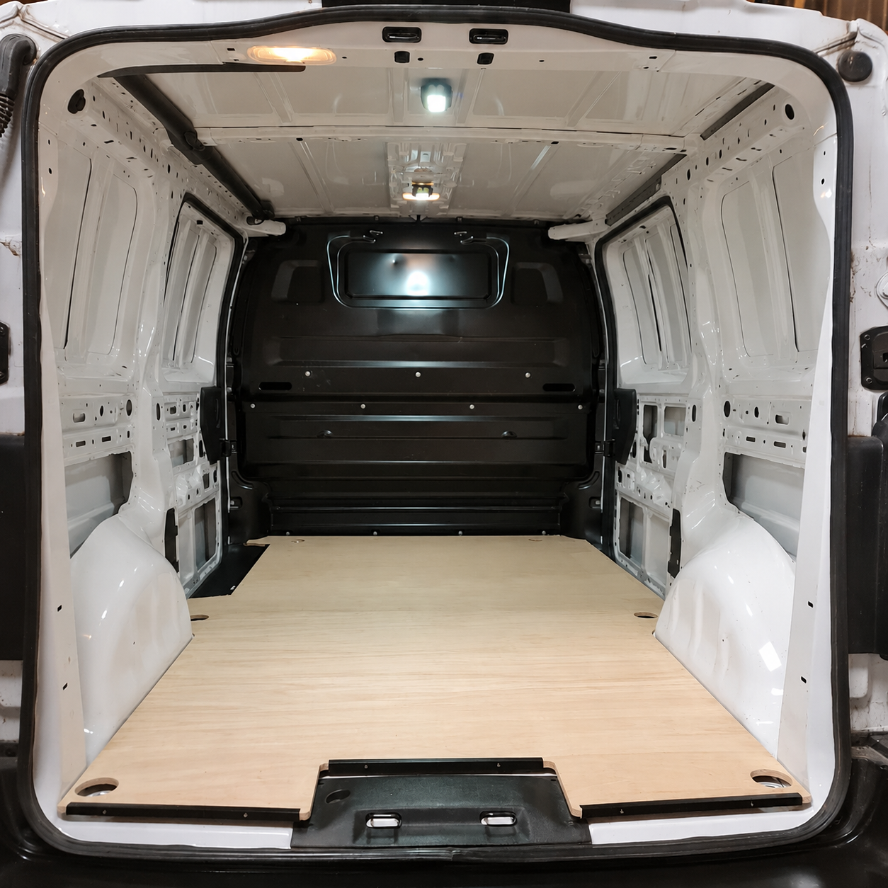 Toyota Proace van cargo area with fitted plywood floor panel and clean white metal interior walls