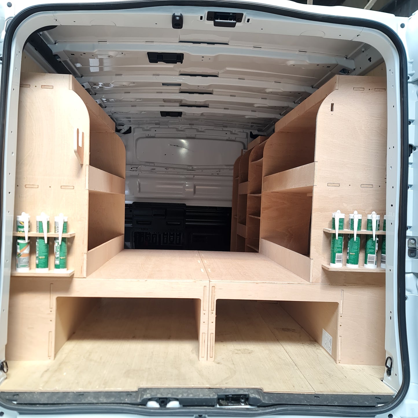 van setup with full racking system and raised floor creating organised mobile workshop space
